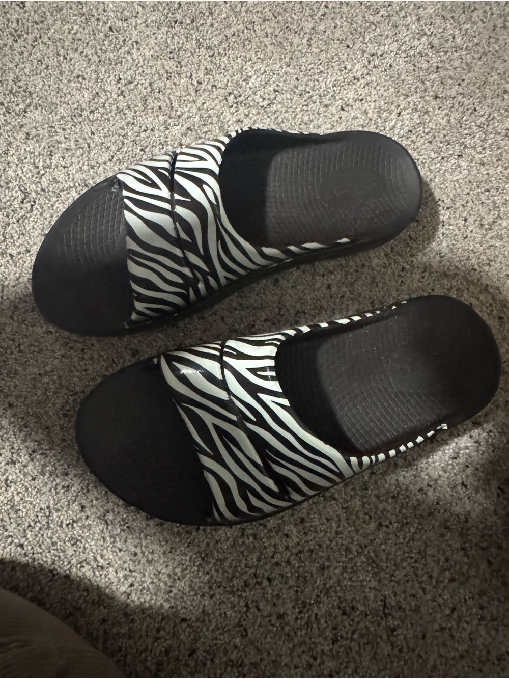 OOFOS Zebra Print Slide Sandals in Black and White